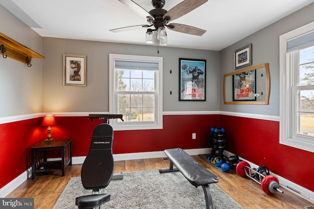 workout room featuring plenty of natural light, light wood-style flooring, and baseboards