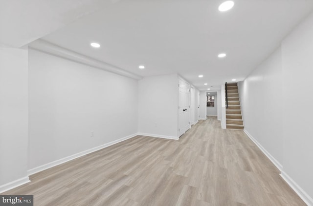 finished basement with light wood-style floors, stairs, baseboards, and recessed lighting