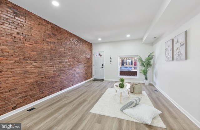 sitting room with visible vents, baseboards, brick wall, wood finished floors, and recessed lighting