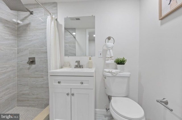 bathroom with baseboards, visible vents, tiled shower, toilet, and vanity