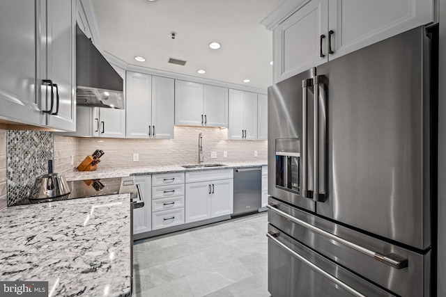 kitchen featuring appliances with stainless steel finishes, ventilation hood, a sink, and tasteful backsplash