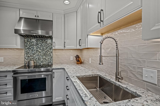 kitchen with under cabinet range hood, a sink, white cabinets, and stainless steel electric stove