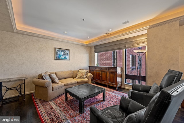 living area featuring a tray ceiling, wood-type flooring, visible vents, and recessed lighting