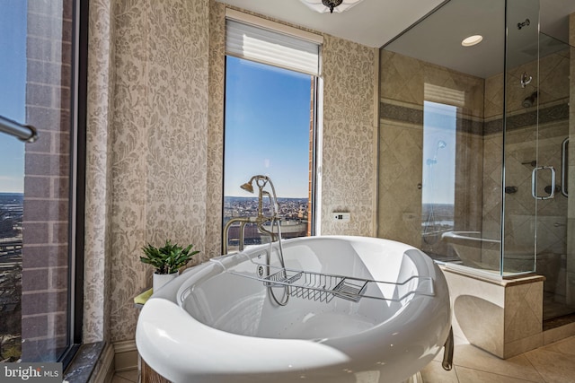 full bath with a stall shower, tile patterned floors, and a soaking tub