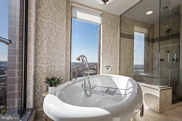 full bath featuring a freestanding tub, a shower stall, and tile patterned floors