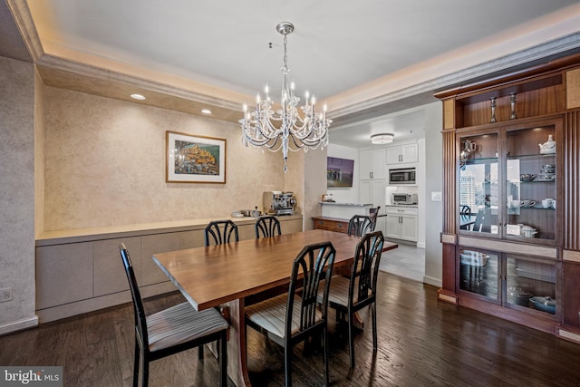 dining space with dark wood-style floors, baseboards, a tray ceiling, and a notable chandelier