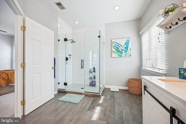 full bath featuring wood finished floors, baseboards, visible vents, recessed lighting, and a stall shower