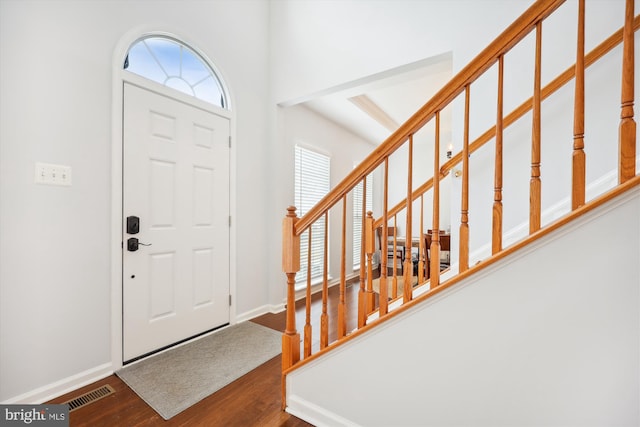 entrance foyer with stairway, wood finished floors, visible vents, and baseboards