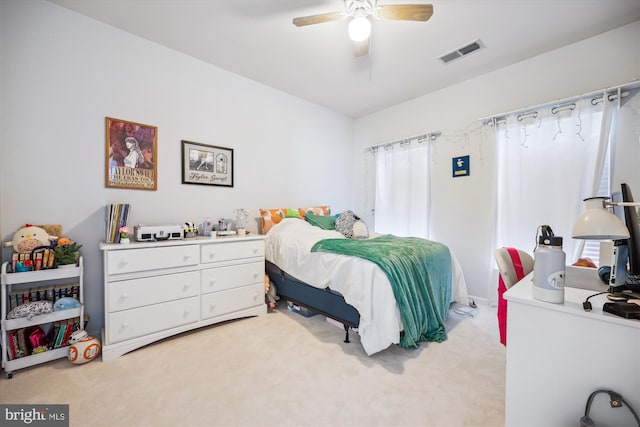 bedroom with visible vents, light colored carpet, and ceiling fan