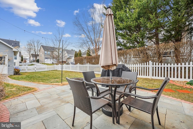 view of patio with outdoor dining space, a residential view, and a fenced backyard