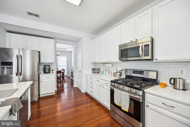 kitchen featuring tasteful backsplash, visible vents, appliances with stainless steel finishes, and dark wood-type flooring