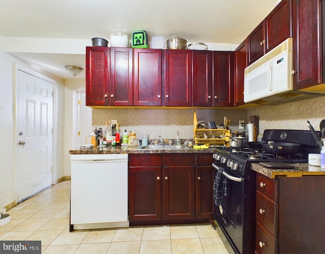 kitchen featuring reddish brown cabinets, white appliances, light tile patterned flooring, and a sink