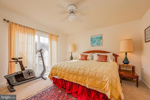 carpeted bedroom with ceiling fan, access to exterior, and a textured ceiling