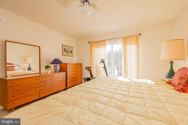 bedroom featuring ceiling fan, access to exterior, and a textured ceiling