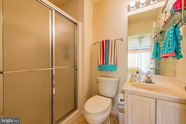 bathroom featuring a shower with door, vanity, tile patterned flooring, and toilet