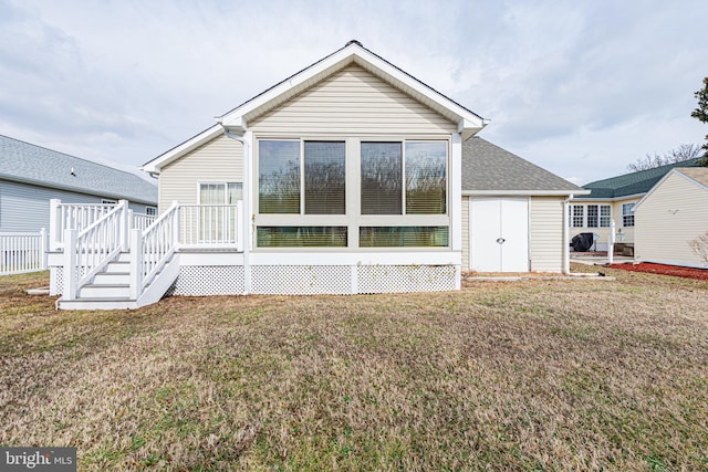 rear view of property featuring a yard and a deck