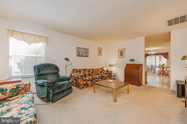 carpeted living room with an inviting chandelier and a textured ceiling