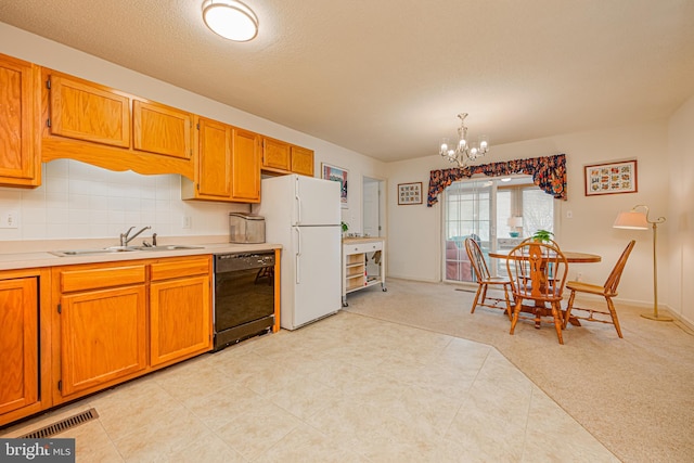 kitchen with sink, an inviting chandelier, black dishwasher, white fridge, and pendant lighting