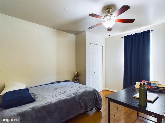 bedroom featuring ceiling fan, baseboards, and wood finished floors