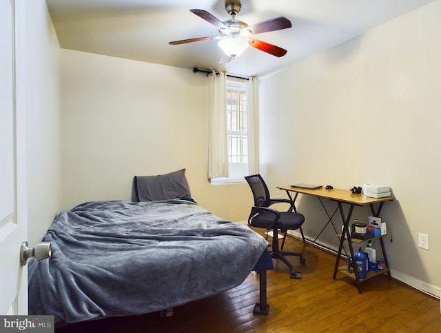 bedroom featuring wood finished floors, a ceiling fan, and baseboards