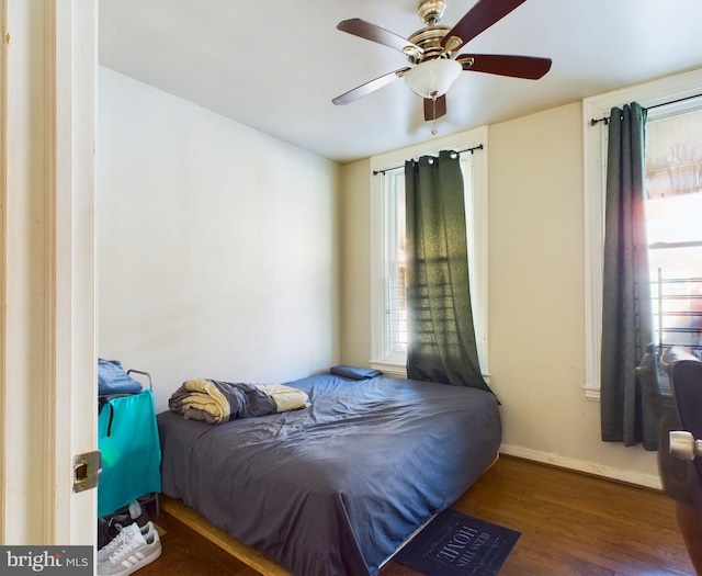 bedroom with ceiling fan, baseboards, and wood finished floors