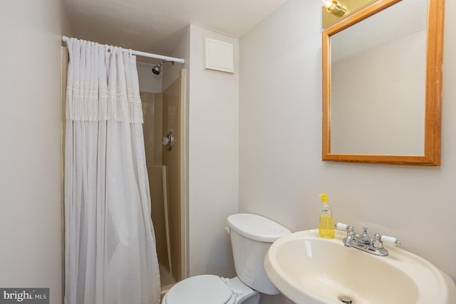 bathroom featuring sink, toilet, and a shower with shower curtain