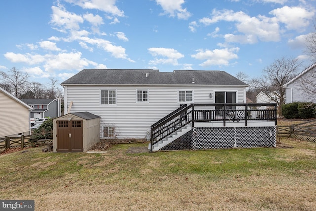 rear view of house with a wooden deck, a yard, and a storage unit