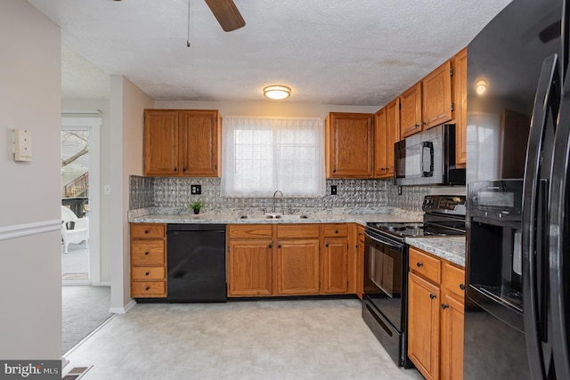 kitchen with sink, ceiling fan, tasteful backsplash, black appliances, and light stone countertops