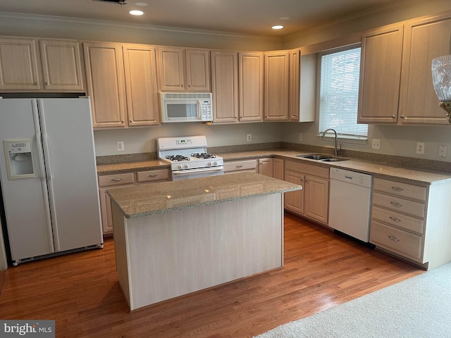 kitchen with white appliances, a sink, light wood-style flooring, and a center island