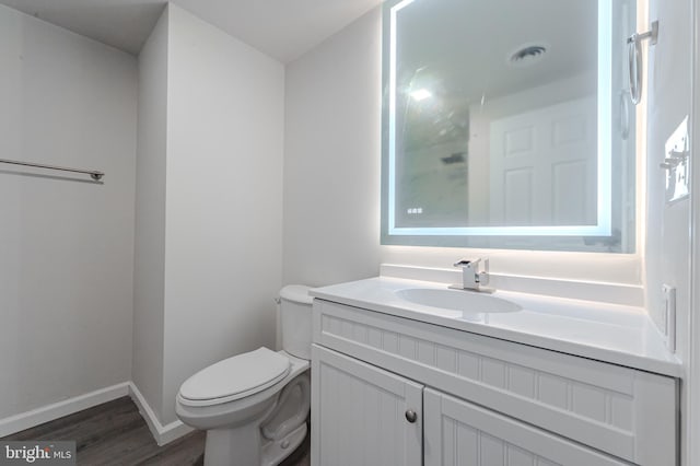 bathroom featuring vanity, hardwood / wood-style flooring, and toilet