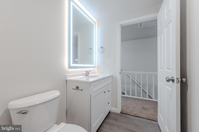 bathroom featuring vanity, hardwood / wood-style flooring, and toilet