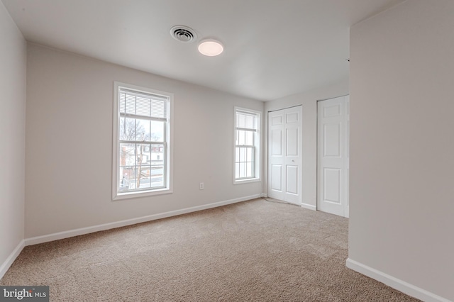 unfurnished bedroom featuring light carpet