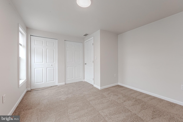 unfurnished bedroom featuring light colored carpet