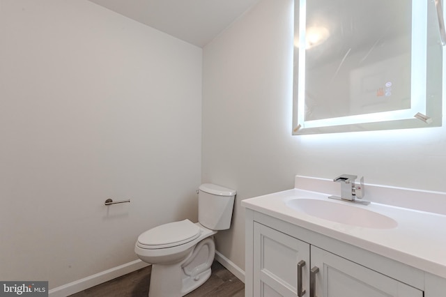 bathroom with vanity, wood-type flooring, and toilet