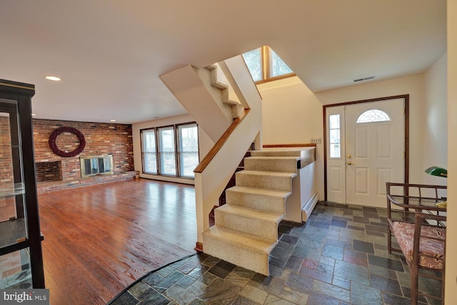 338 Blue Heron Rd, Dover, DE 19904 - entrance foyer featuring a fireplace, a baseboard radiator, and brick wall