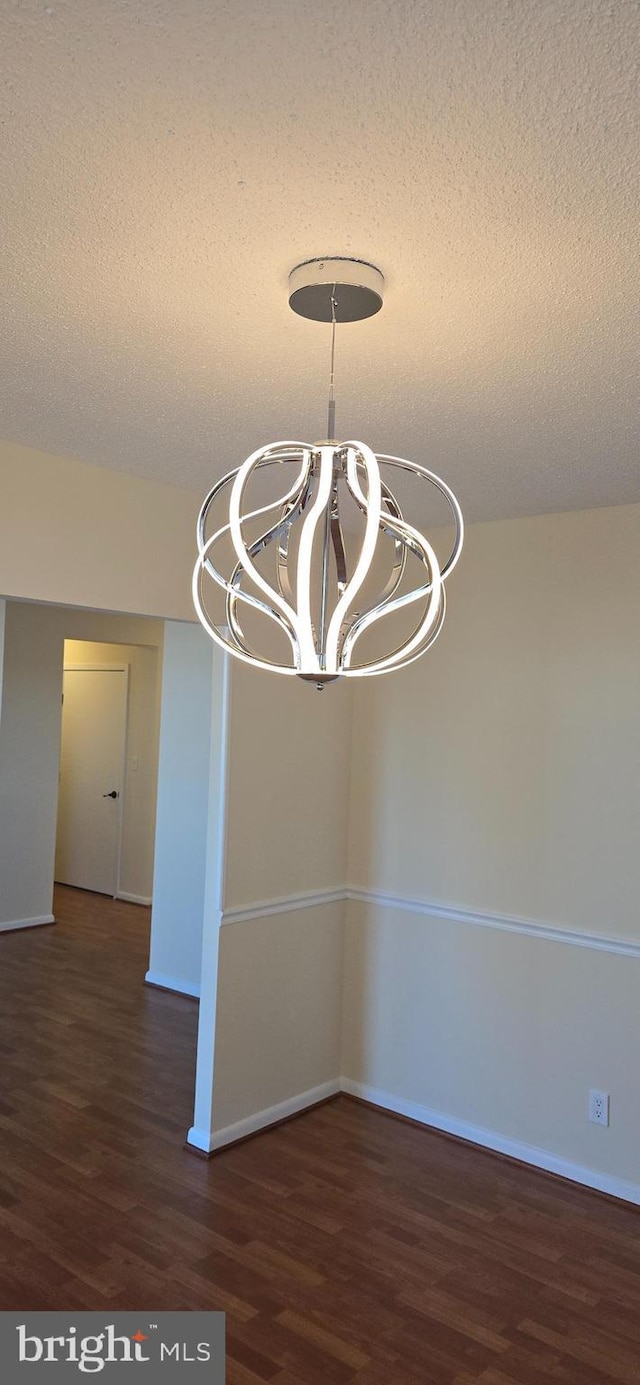 interior space featuring wood finished floors, a textured ceiling, and an inviting chandelier