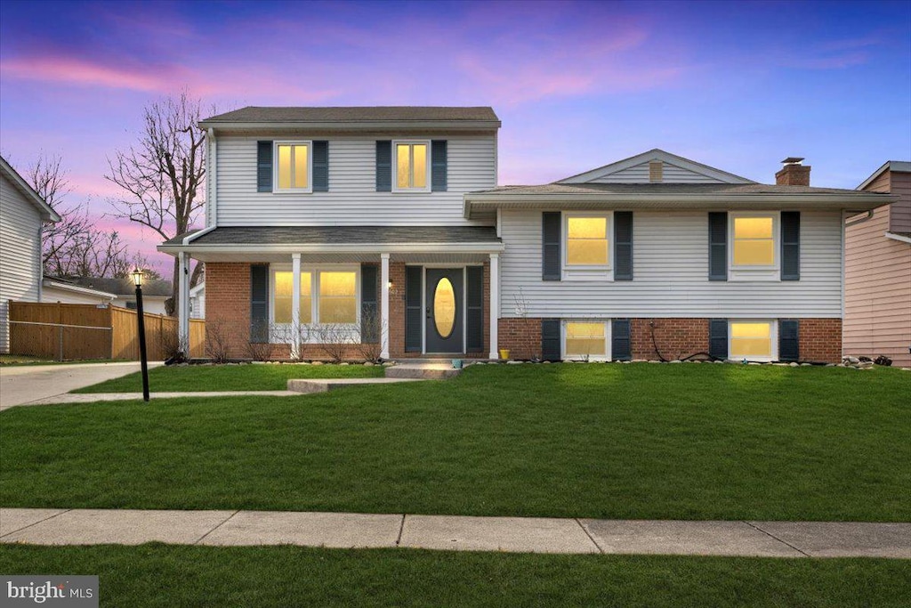 split level home featuring a yard and covered porch