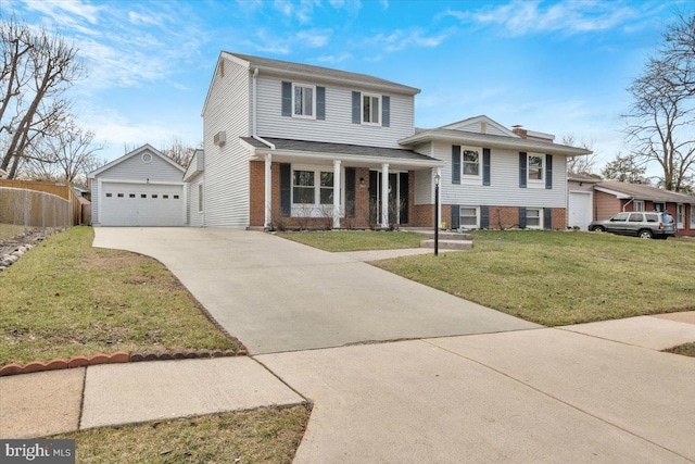 tri-level home featuring an outbuilding, a garage, covered porch, and a front yard