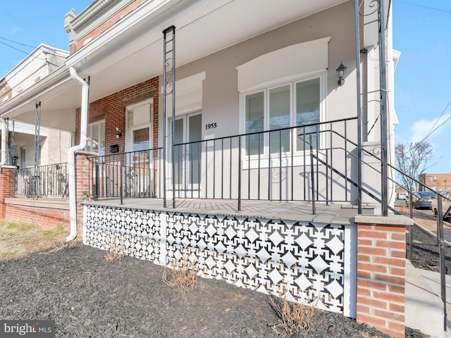 view of side of home featuring covered porch