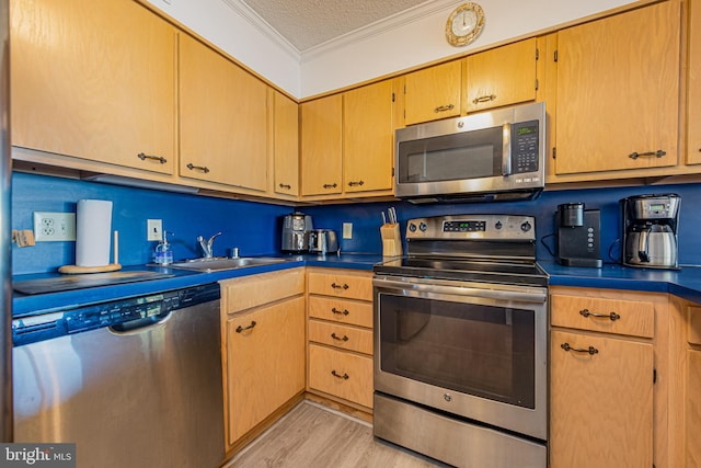 kitchen with sink, crown molding, appliances with stainless steel finishes, light hardwood / wood-style floors, and a textured ceiling