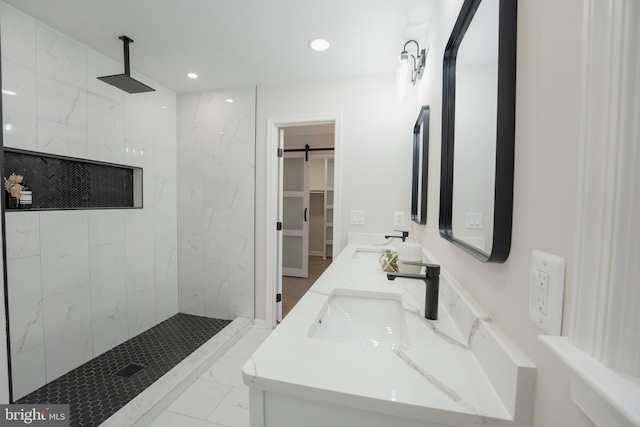 full bath featuring recessed lighting, marble finish floor, a marble finish shower, and a sink