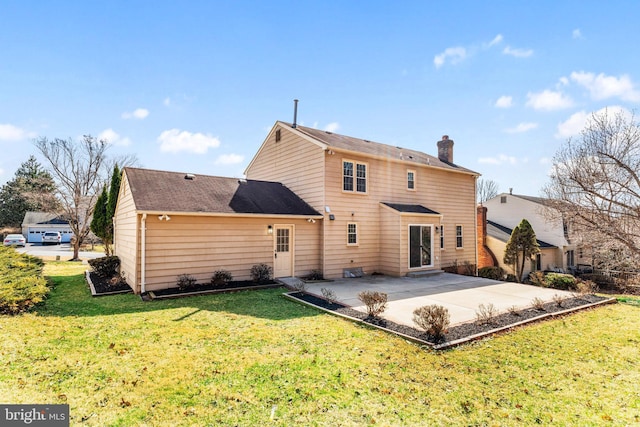 back of house featuring a patio area, a lawn, and a chimney