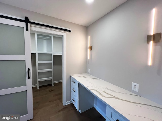 office space featuring a barn door and dark wood-type flooring