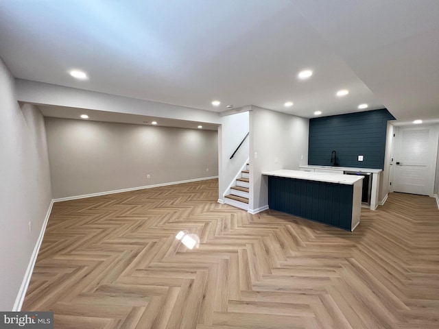 interior space featuring recessed lighting, stairs, baseboards, and a sink