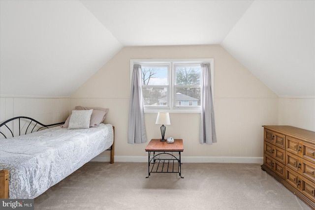 bedroom with lofted ceiling, baseboards, and light colored carpet