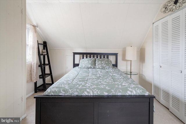 bedroom with lofted ceiling, wooden walls, a closet, and light colored carpet