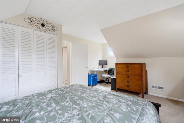 bedroom with lofted ceiling, a closet, visible vents, and light carpet