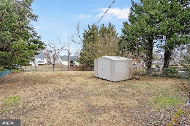 view of yard featuring a storage shed, an outbuilding, and a fenced backyard