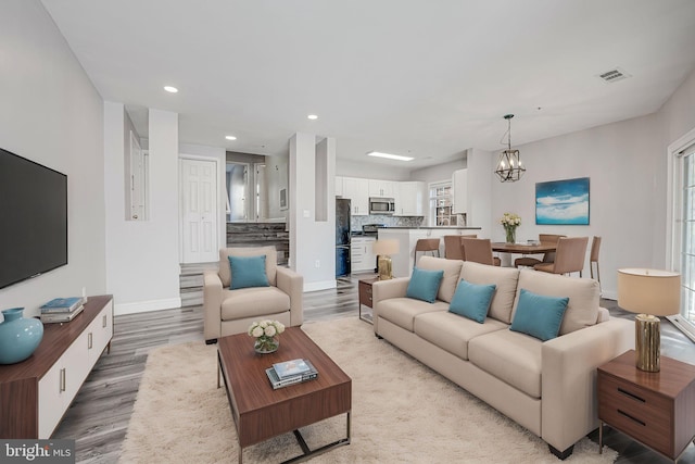 living room featuring a notable chandelier and light hardwood / wood-style floors