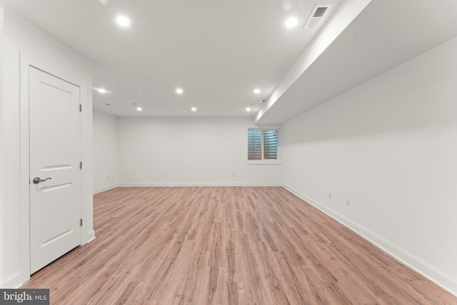 basement with light hardwood / wood-style flooring